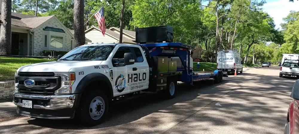Halo Plumbing Services branded trucks in a Houston neighborhood